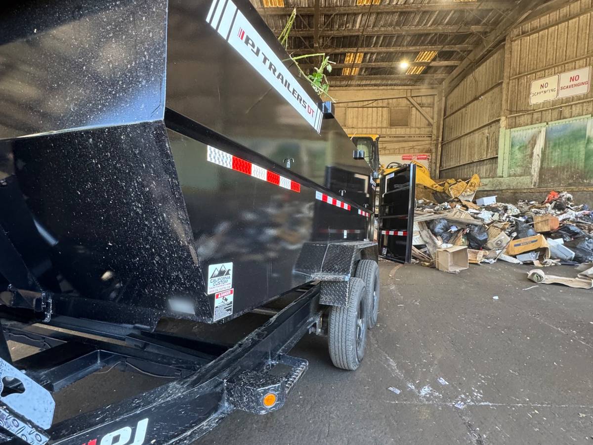 Our black PJ dump trailer parked on the tipping floor of a transfer station to unload